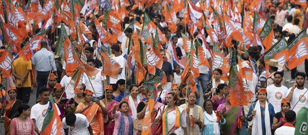 Bharatiya Janata Party (BJP) supporters holding BJP flags arrives to to see a roadshow of Union