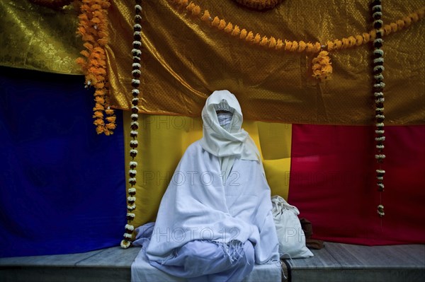 Asian female pilgrim meditating in the Mahabodhi temple, buddhist pilgrimage site at Bodhgaya,