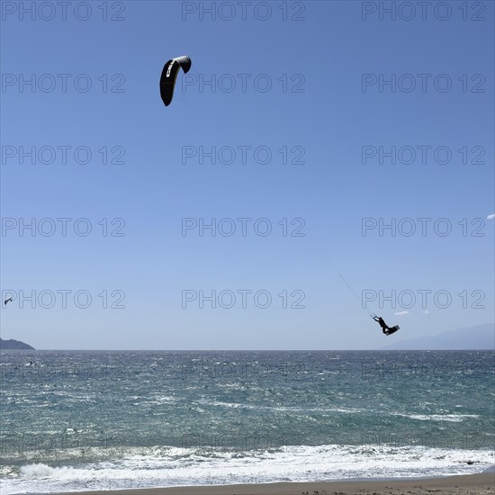 Kitesurfer Kitesurfer takes off in strong wind and waves rough sea moving sea flies with inflated