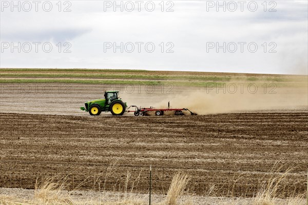 Schaller, Iowa, A cloud of dust blows behind the tractor as a farmer plows his field on a windy day