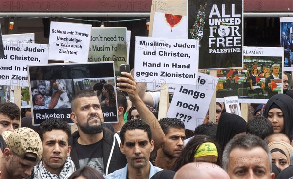 Muslims, Jews and Christians, hand in hand against Zionists, can be read on a poster during the Al