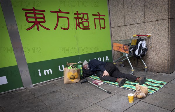 Homeless, Berber, sleeping, lying on pavement, Bible, shopping trolley, belongings, bag, Chinese