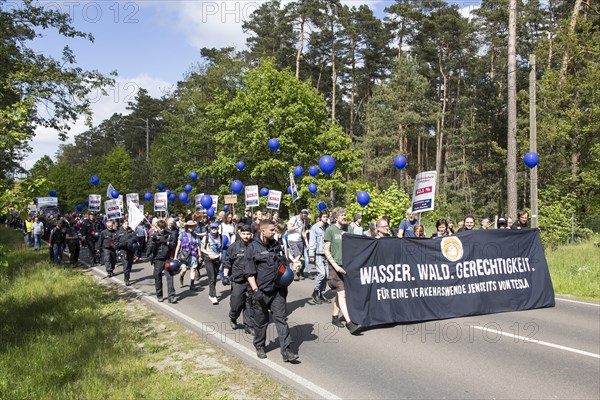 Participants with banner Water. Forest. Justice. For a traffic turnaround beyond Tesla and balloons