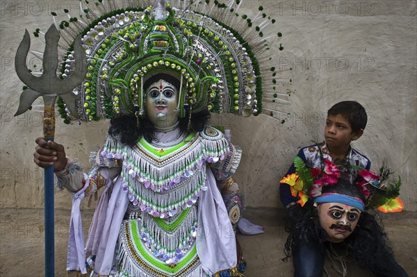 Purulia Chhau dancer playing the role of the hindu god Shiva, the son of the dancer is watching his