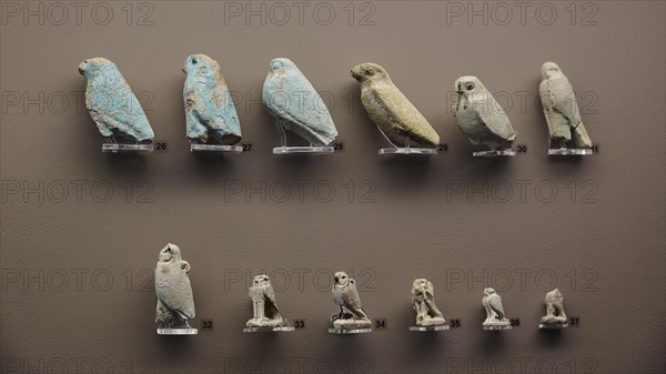 Miniatures, Falcons, Various small bird statues in blue and beige, lined up against a neutral