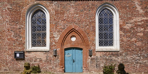 Window and entrance door to St Laurentius Church in Toenning, North Friesland district,