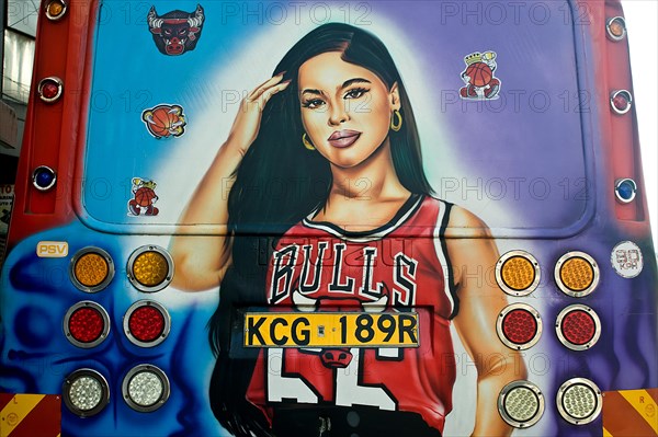 Decorated public transport called Matatu, young woman fan of the basket ball team Chicago Bulls,