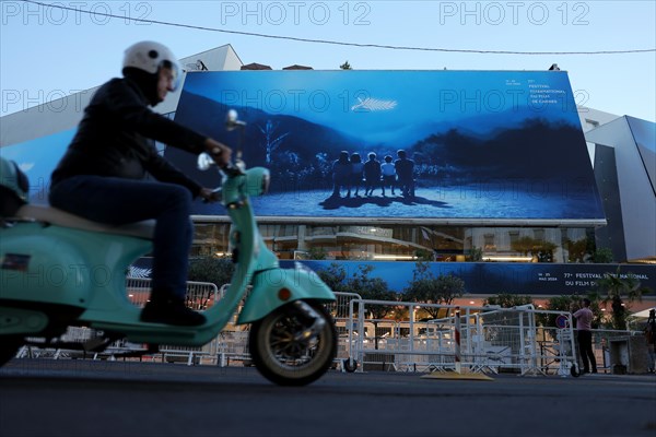 Cannes, France, 13 May 2024: A moped rides in front of the Palais des Festivals et des Congres on