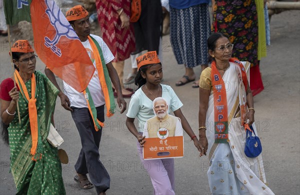 Bharatiya Janata Party (BJP) supporters arrives to to see a roadshow of Union Home minister Amit