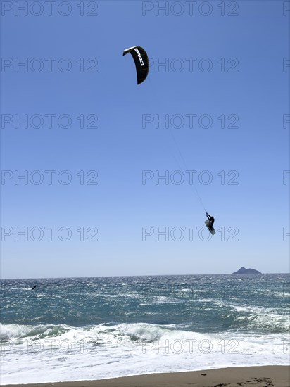 Kitesurfer Kitesurfer takes off in strong wind and waves rough sea moving sea flies with inflated