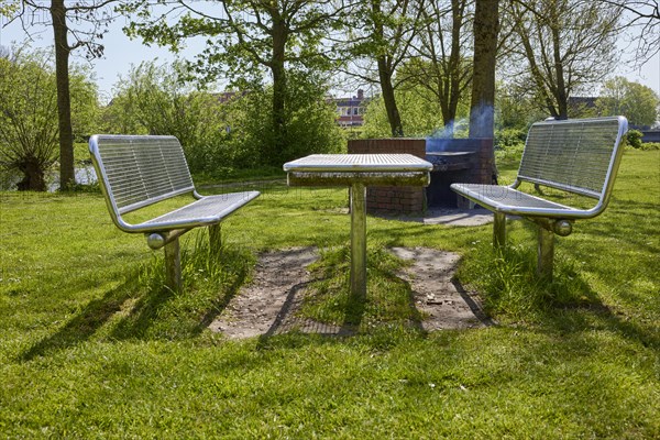 Public barbecue area with brick-built, smoking barbecue and stainless steel tables and benches in