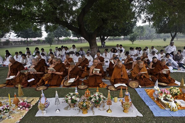 Asian tourist buddhists and nuns on pilgrimage, reading scriptures in front of the relic stupa at
