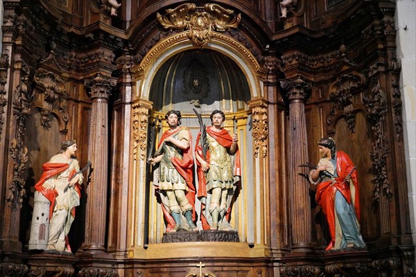 Iglesia San Nicolas de Bari, altar in a church with ornate wood carvings and statues of two holy