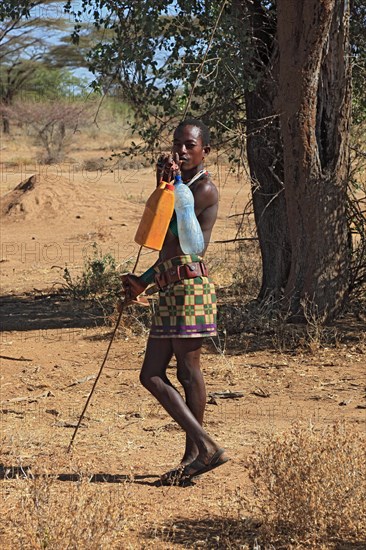 South Ethiopia, Omo region, man from the Karo people with water bottles, plastic bottles filled
