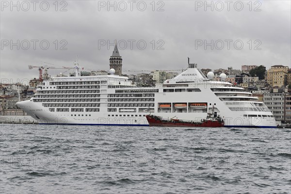 Cruise ship SILVERSEA, against the backdrop of Istanbul and the Galata Tower on a cloudy day,