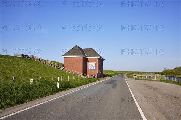 Country road, dyke and dyke house with stairs to the top of the dyke near Tetenbuell, Nordfriesland