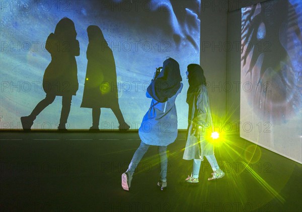 Two woman look at an exhibition by the German artist Otto Piene in Tehran on 6 April 2015 and make
