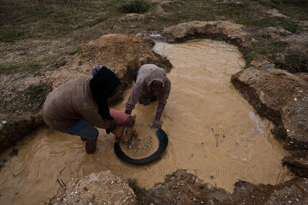 Woman and teenage girl looking for gold. Near Ambositra, Madagascar. Both belong to the Betsileo
