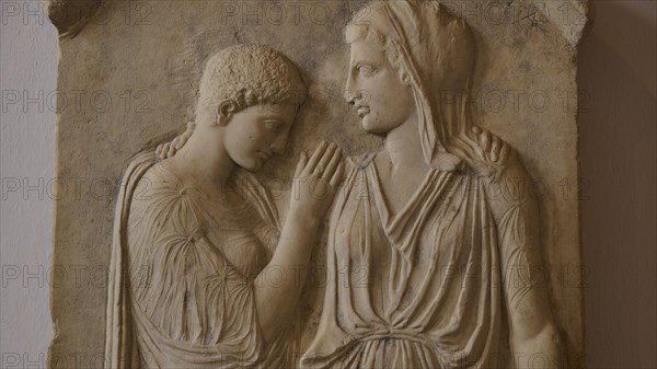Krito and Timarista, close-up of an ancient bas-relief, two woman in classical dress, intimate
