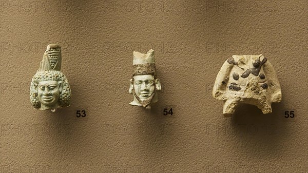 Eastern Greek or Rhodian workshop, Three ancient stone masks in detail view on a wall, interiors,