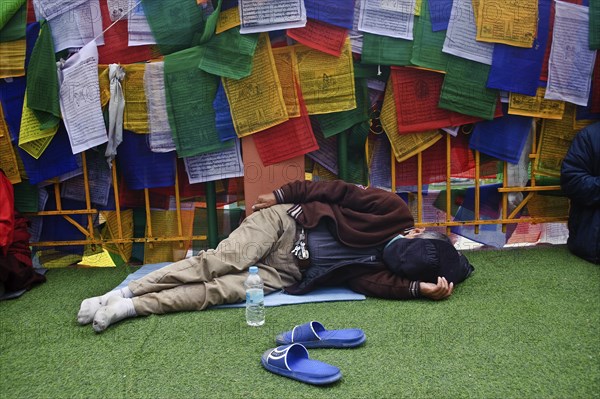 Asian buddhist pilgrim sleeping in the Mahabodhi temple complex, Bodhgaya, Bihar, India. The