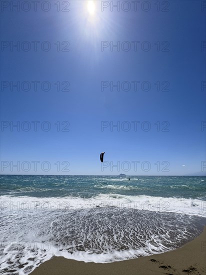 Kitesurfer kite surfer surfing in strong wind and waves rough sea moving sea with inflated sail, in