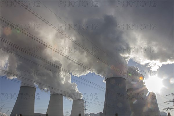 Steam rises from the cooling towers of the Vattenfall power plant in Jaenschwalde, power lines and