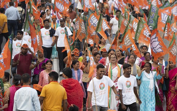 Bharatiya Janata Party (BJP) supporters holding BJP flags arrives to to see a roadshow of Union