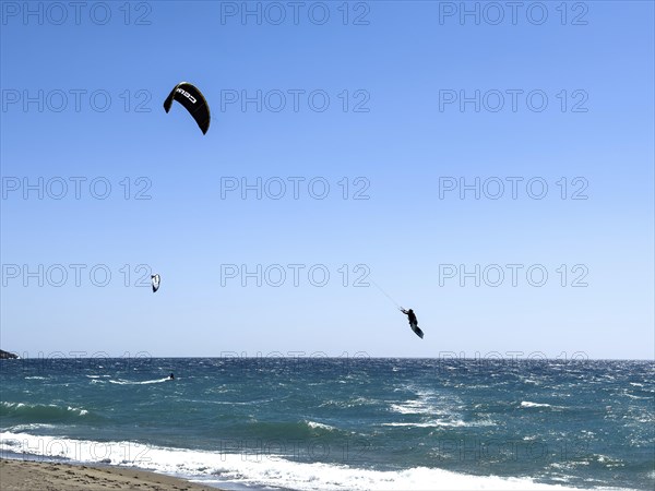 Kitesurfer Kitesurfer takes off in strong wind and waves rough sea moving sea flies with inflated