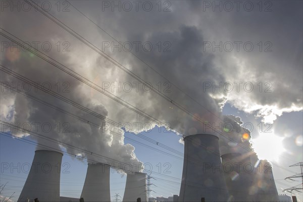 Steam rises from the cooling towers of the Vattenfall power plant in Jaenschwalde, power lines and