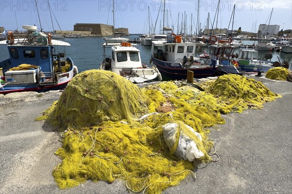 In the foreground yellow fishing nets of local Greek fishermen behind them several small fishing