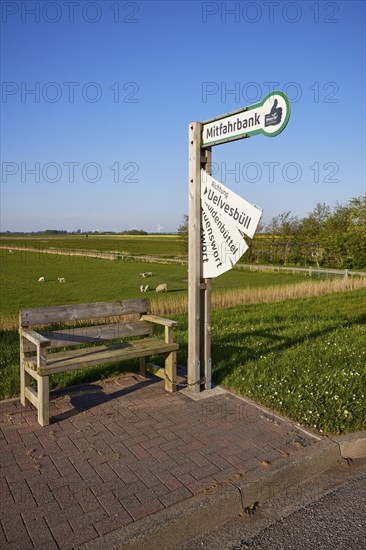 Carpooling bench and sign with fold-out destination boards in the marshland near Simonsberg,