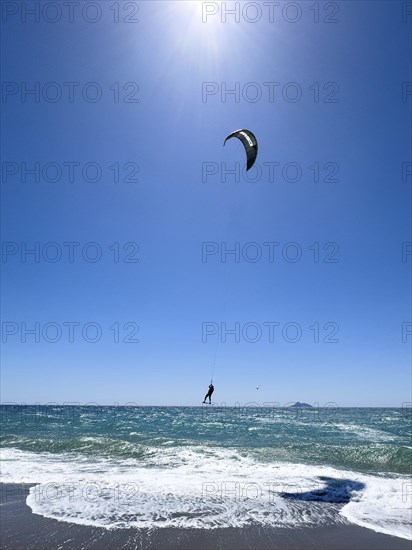 Kitesurfer Kitesurfer takes off in strong wind and waves rough sea moving sea flies with inflated