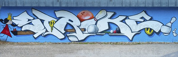 Large graffiti on a wall with the word 'strike' surrounded by colourful elements, painting of the
