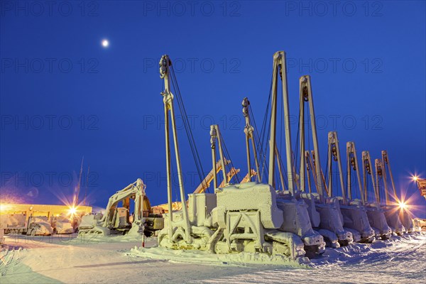 Cranes and equipment for oil production in the snow, twilight, Deadhorse, Alaska, USA, North