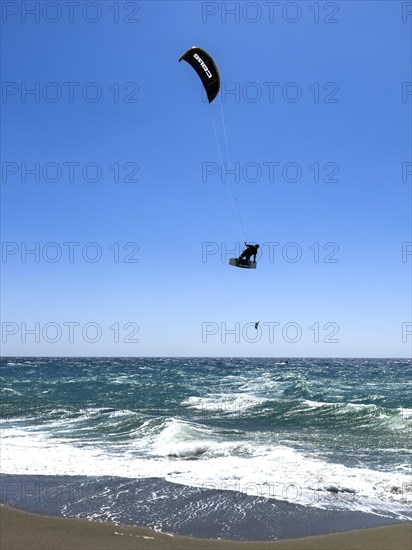 Kitesurfer Kitesurfer takes off in strong wind and waves rough sea moving sea flies with inflated