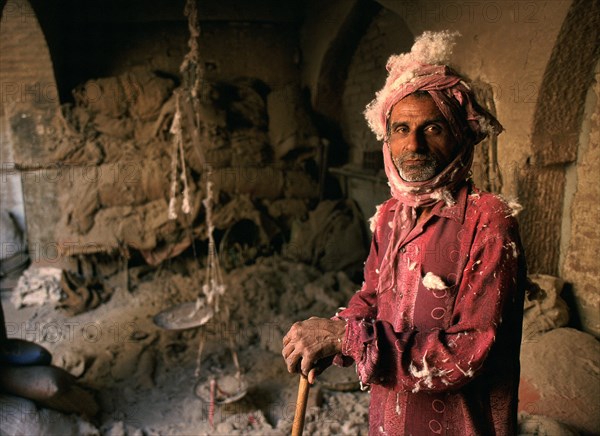 Portrait of a man making woollen mattresses, dirty and dusty work, Bikaner, Rajasthan, India, Asia