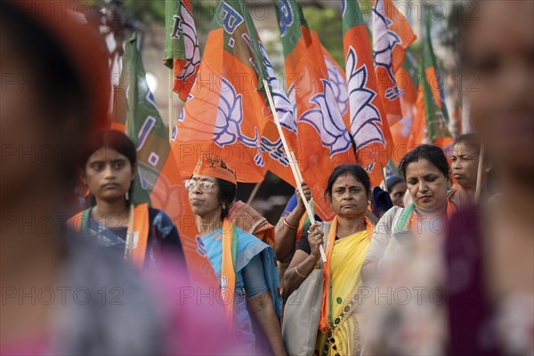 Bharatiya Janata Party (BJP) supporters holding BJP flags arrives to to see a roadshow of Union