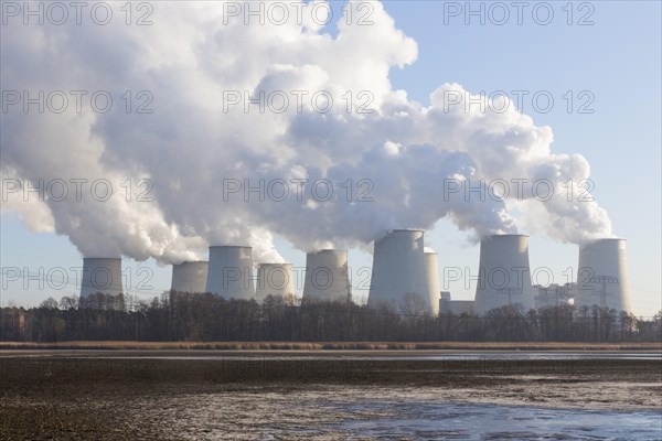 Steam rises from the cooling towers of the Vattenfall power plant in Jaenschwalde, power lines and