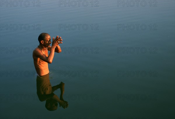 Hindu man worshipping the sun god in the Gandaki river, Nepal, Asia