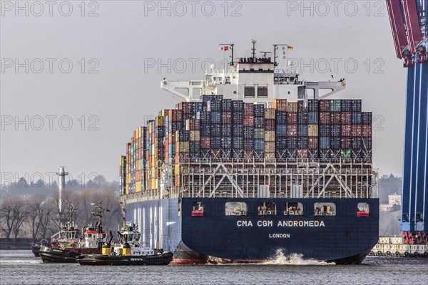 A container ship of the CMA CGM shipping company is brought to Burchardkai in the Port of Hamburg