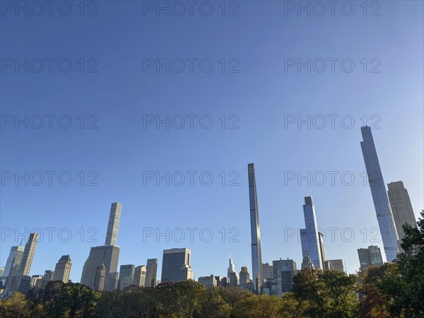 Cityscape with towering skyscrapers and autumnal trees in central park, the skyline of new york