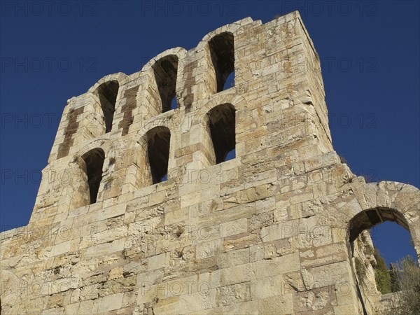 Ancient stone structure with several arches in front of blue sky, Ancient building with columns and