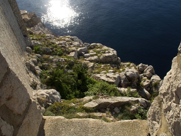 Rocky coast sloping into the sunny sea, the old town of Dubrovnik with historic houses, churches,