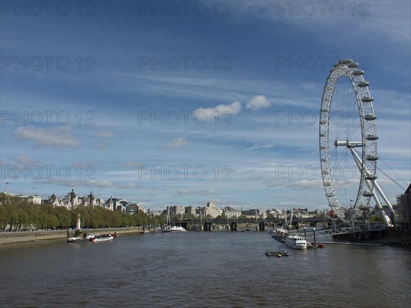 View of the River Thames in London with the London Eye and city views in the background under a