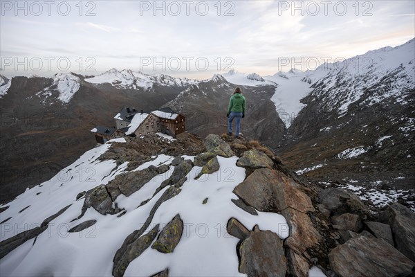 Hiker looking at mountain panorama and glacier, mountain hut Ramolhaus with snow, view of Gurgler