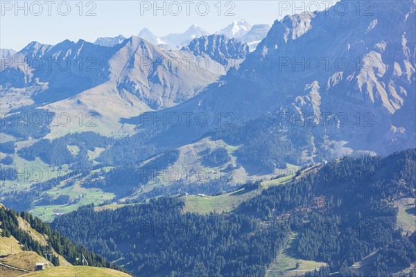Vast mountain landscape with deep valleys, green forests and illuminated sunlight, mountain