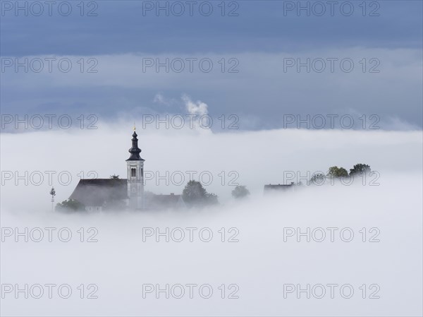Church tower rises out of the morning mist, Frauenberg pilgrimage church, near Leibnitz, Styria,