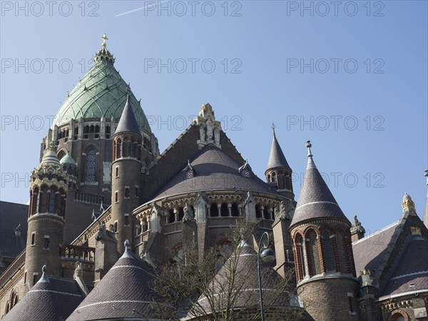 An impressive cathedral with a green dome and Gothic architecture under a blue sky, Haarlem,