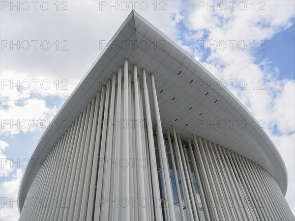 Close-up of a modern building in Luxembourg with vertical columns and blue sky in the background,